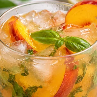 Peach Basil Arnold Palmer: Summer Sip - Discover the ultimate Peach Basil Arnold Palmer! This refreshing drink blends grilled peaches, fresh basil, lemon, and h